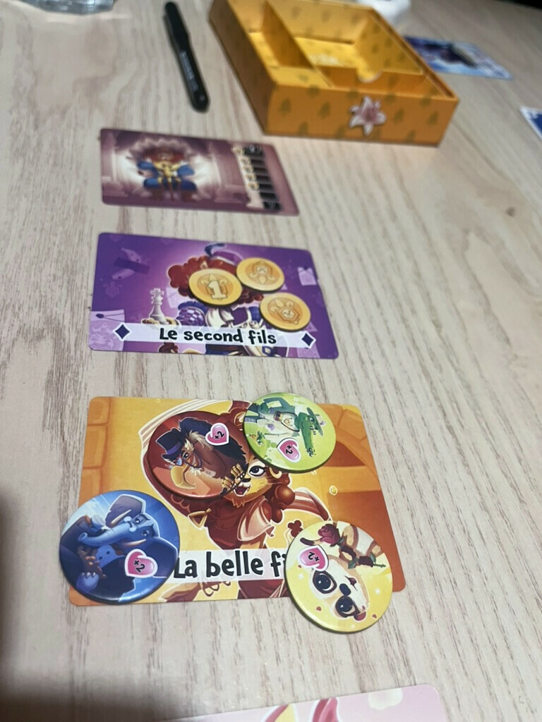 Trois jetons Courtisan réunis sur la carte de la belle-fille, dans La Part du Lion.