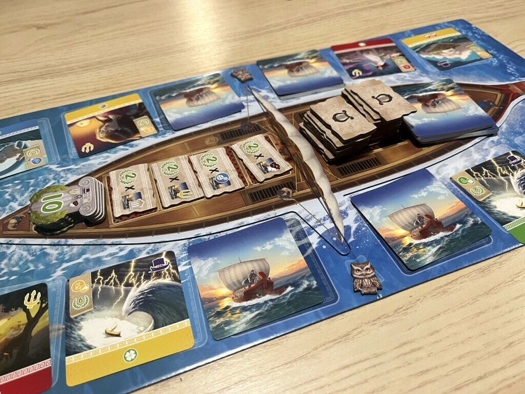 Navire central du jeu Odysseus entouré des cartes Épreuve et des jetons Récit